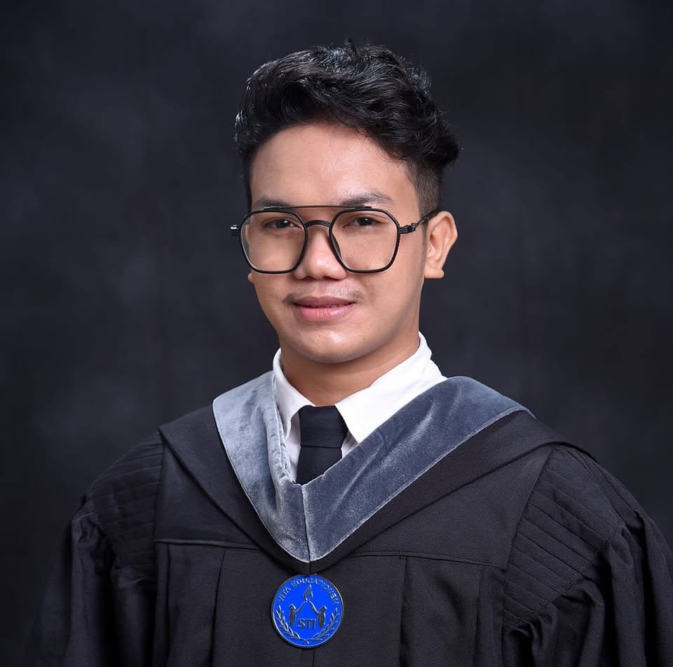 Mark Allan Carba, owner of Carba's Home, wearing glasses and a graduation gown